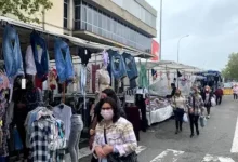 Puestos de ropa en la calle con visitantes en el Mercado de Pulgas de Ca n’Aurell