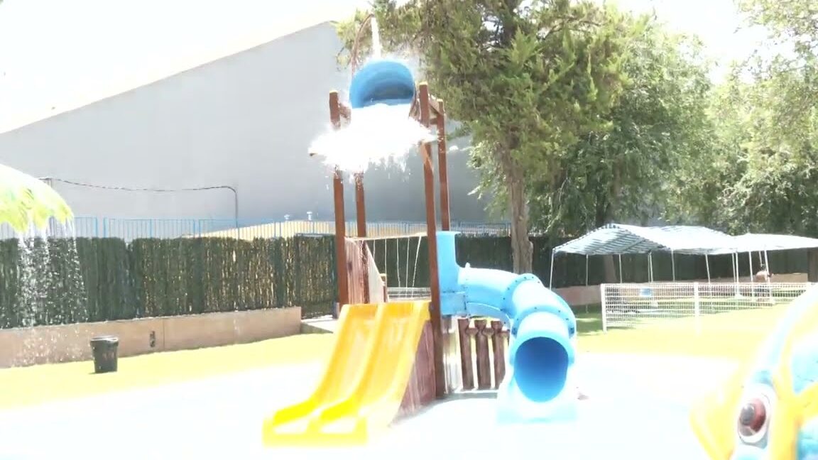 Área de juegos acuáticos con toboganes amarillos, tobogán tubular azul y cubo que vuelca agua en el Mercadillo Navideño de El Coronil