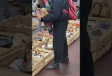 Persona revisando cajas de objetos y vajilla en la Feria de Brocantes de Plaça Frederic Soler