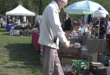 Personas recorriendo puestos con radios, lámparas y objetos antiguos en la Feria de Anticuarios y Brocanters de Caldes de Montbui