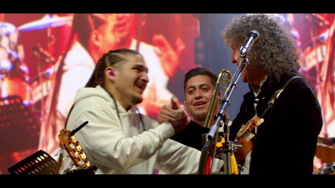 Tres músicos en el escenario intercambian un apretón de manos entre guitarras y trombón durante la Feria de de Santa Llúcia de Arboç