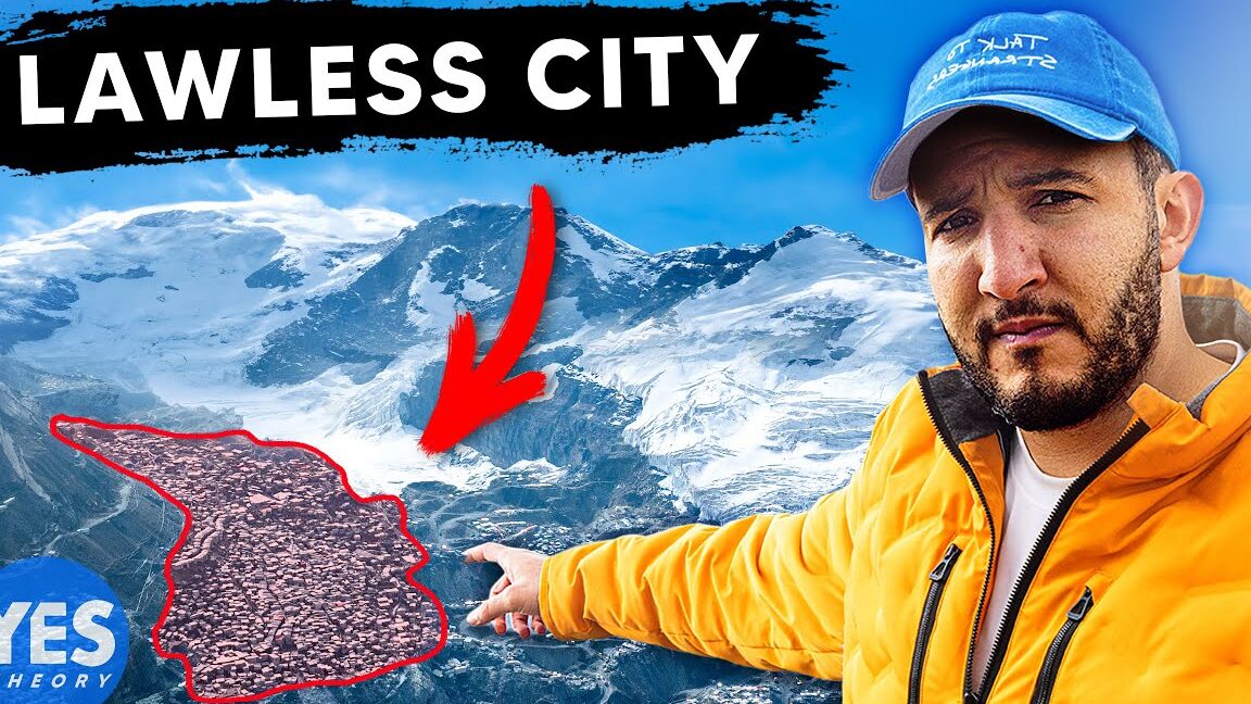 Hombre con chaqueta amarilla señalando un pueblo resaltado en un paisaje montañoso nevado, ideal para Mercadillo Navideño de San José de la La Rinconada.