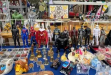 Mesa con figuras de acción, coches de juguete y objetos vintage en el Mercadillo de Benahavís.
