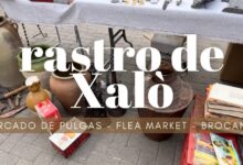 Mesa de mercado con jarras de cerámica, herramientas metálicas, libros y cajas en el Mercadillo de Antigüedades de Villarreal.
