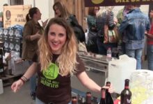 Puesto de vinos y vendedora sonriente en el Mercadillo de Fontanars dels Alforins