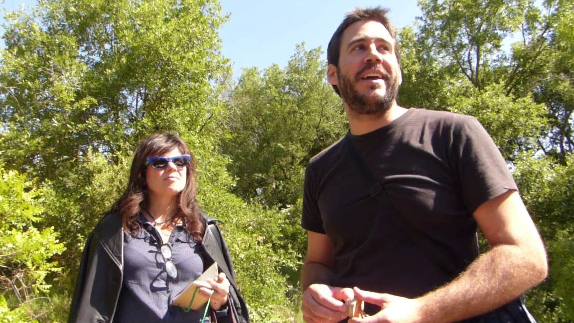 Dos personas al aire libre entre árboles en el Mercadillo Ecológico de Estella-Lizarra