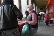 Personas mirando puestos de coleccionismo bajo arcos en el Mercadillo Filatélico y Numismático de Sevilla.