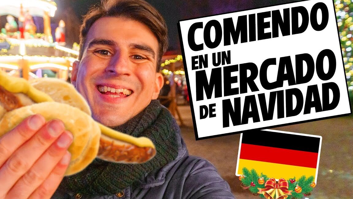Persona sonriente sosteniendo comida callejera en el Mercadillo Navideño del Hotel Maritim Playa entre luces y puestos decorados