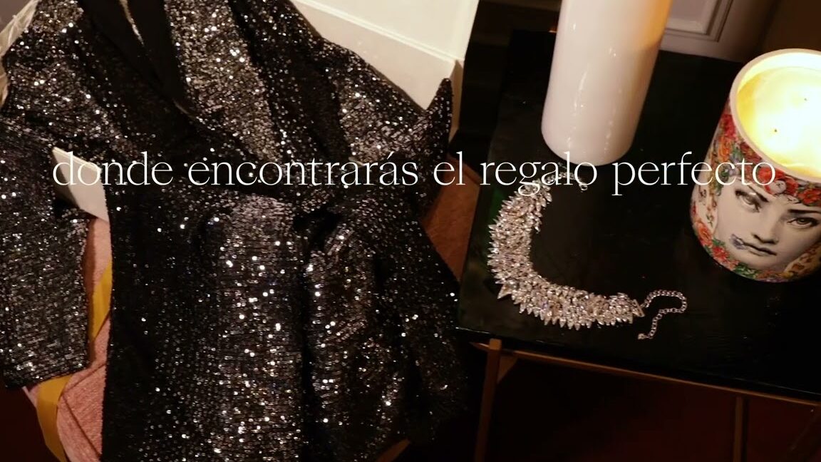 Prenda de lentejuelas negra, collar brillante y vela decorativa en un puesto del Mercadillo Navideño de Las Rozas