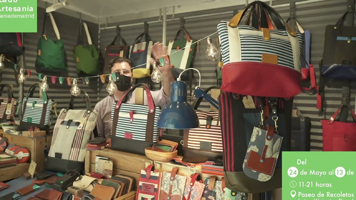 Puesto de bolsos, monederos y accesorios artesanales con luces y decoración en el Mercado de Navidad de Alicante.
