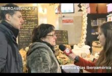 Vendedora atendida en el Mercado Ecológico de la Malagueta durante una entrevista junto a puestos de frutas y verduras.
