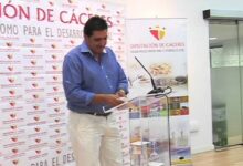 Orador junto a un atril durante la presentación del Mercado Ecológico de Palazuelos de Eresma con fondo de la Diputación de Cáceres