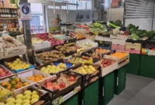 Puesto de frutas y verduras con cajas de manzanas, kiwis y hortalizas en Mercadillo de Antigüedades de Ponteareas