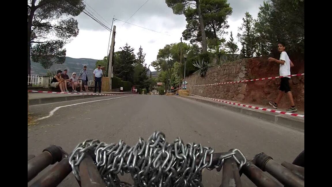 Vista a ras de suelo de un carrito artesanal y espectadores en la Feria de Santa Llúcia de Riells del Fai