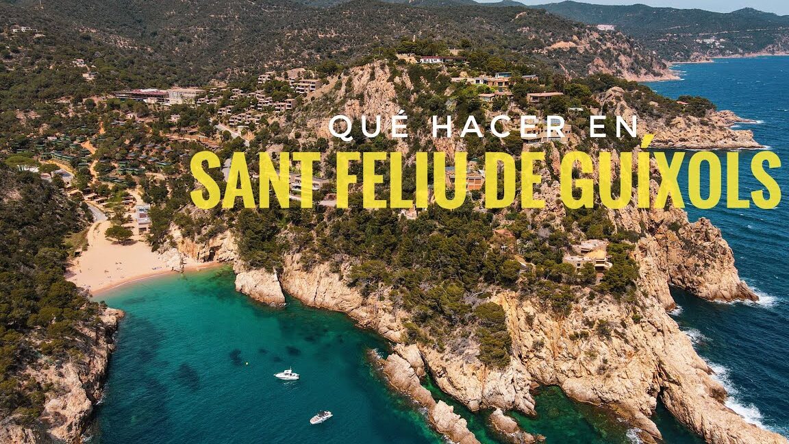 Vista aérea de la cala, acantilados y aguas turquesa junto a viviendas y embarcaciones para la Feria de Navidad de Sant Feliu de Guíxols.